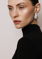 Les Classiques collection featuring Bulle earrings worn by a beautiful model photographed from the side